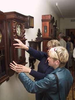 Laikrodi muziejuje aklieji liesdami apiri eksponatus